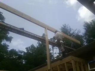Carpenter setting a ridge beam over a new addition frame — Ice Dam Removal by Roofing Brothers in Crockett