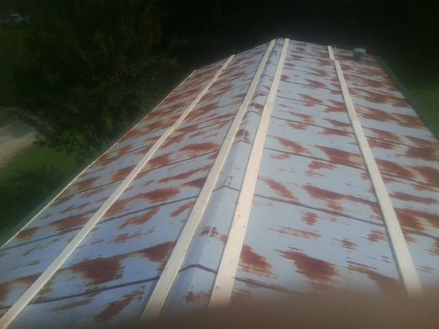 Rusted metal roof panels with new wood purlins before replacement — Storm Damage Roof Repair in Crockett by Roofing Brothers