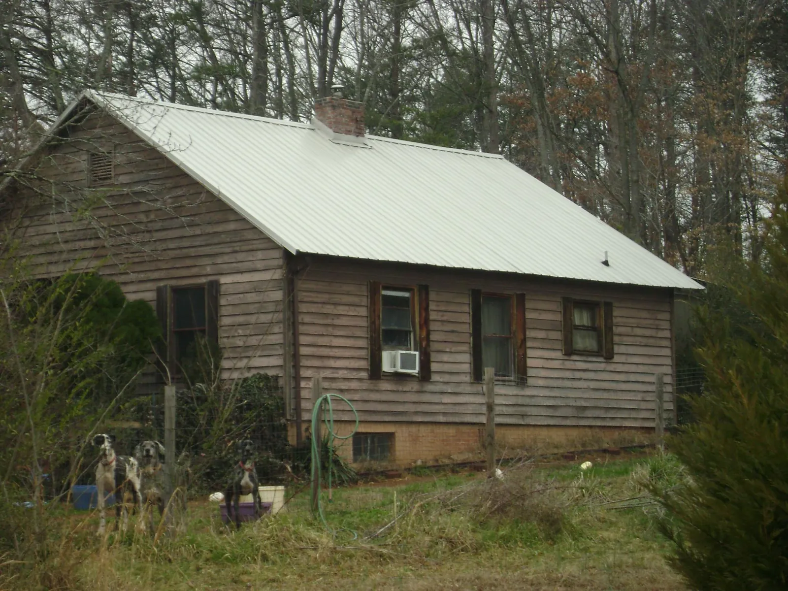 White metal roof on an old wood sided farmhouse, from a Metal Roof Installation job in Crockett